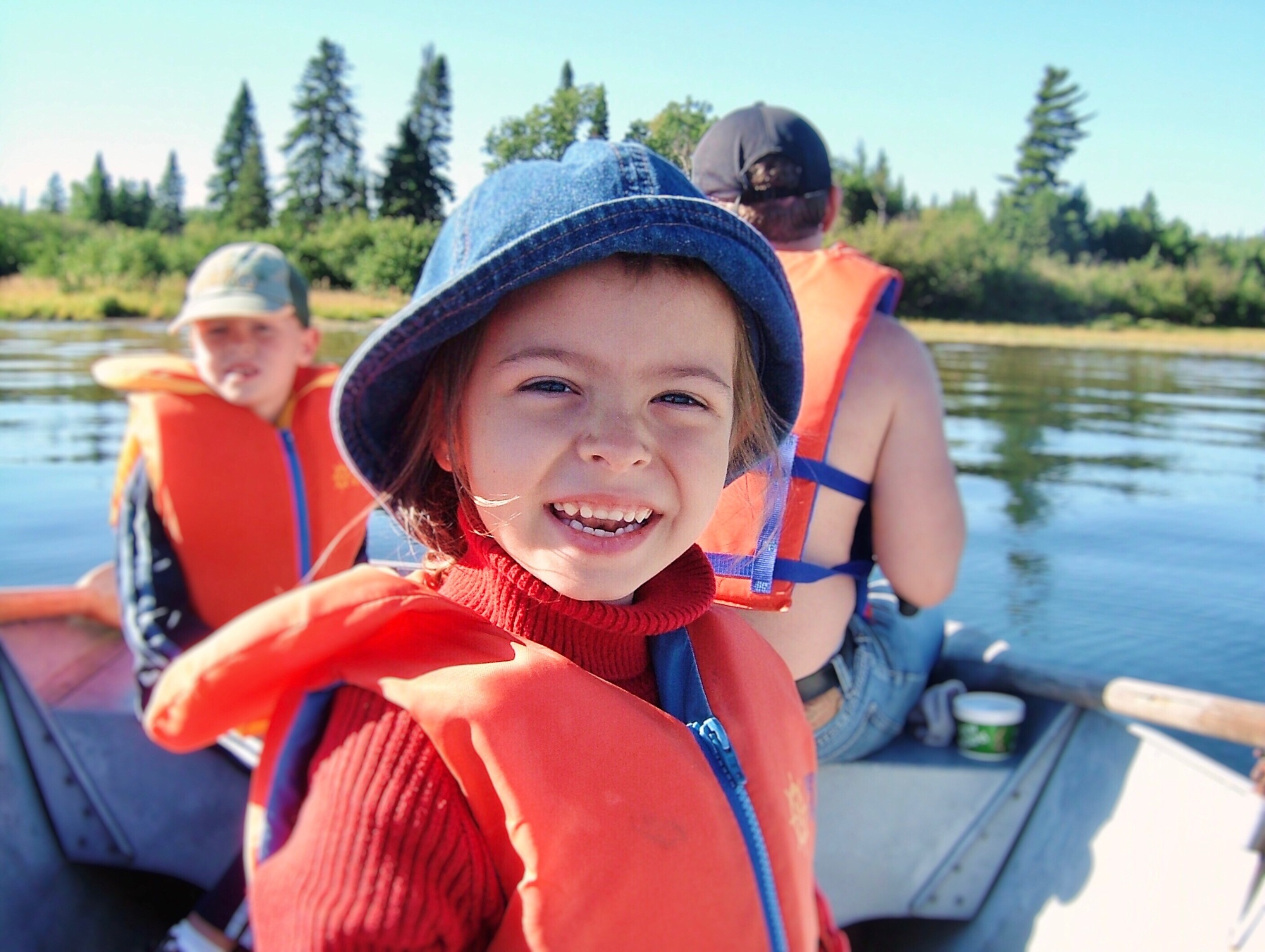 Portrait of little girl smiling while with family on a boat on lake fishing